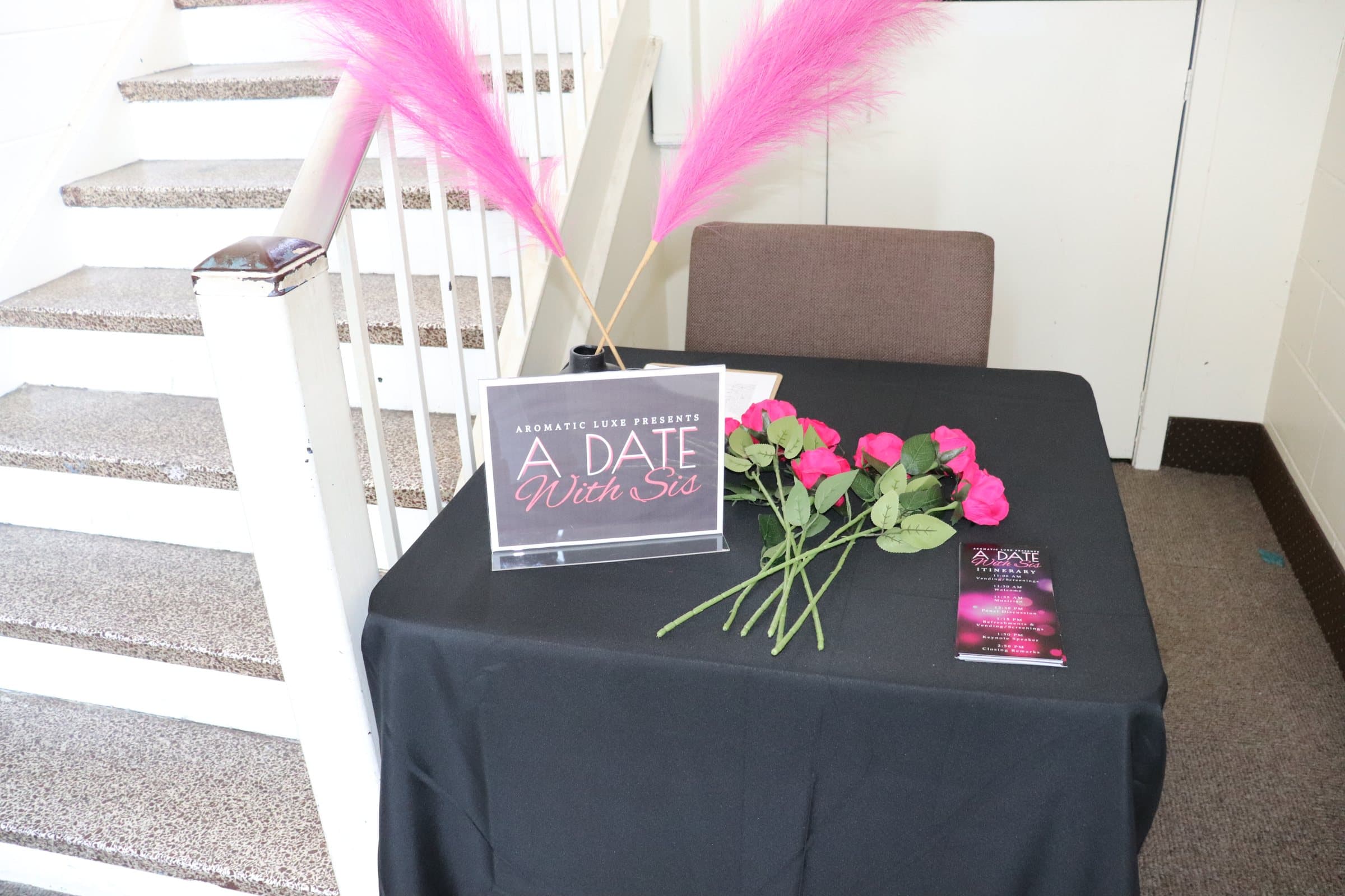 A Date With Sis welcome table with pink roses