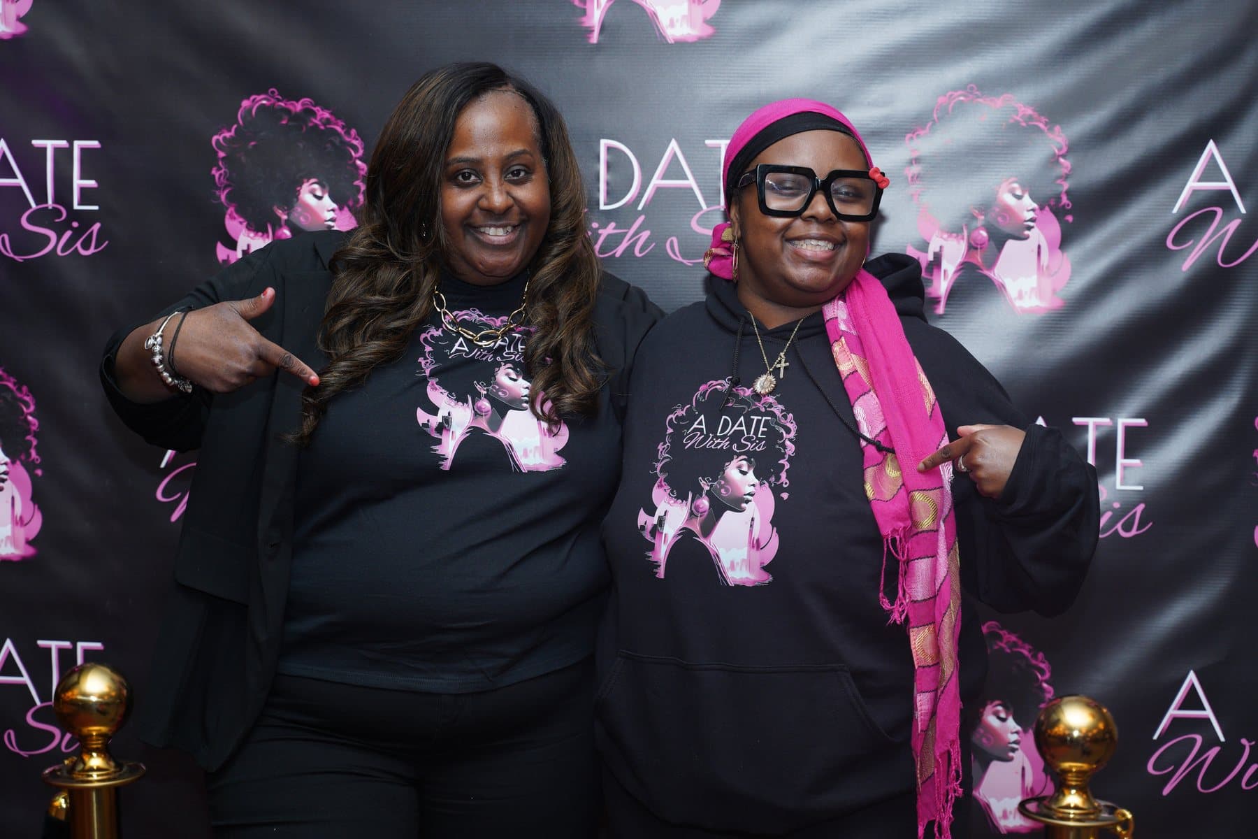 Guests smiling together at the A Date With Sis backdrop