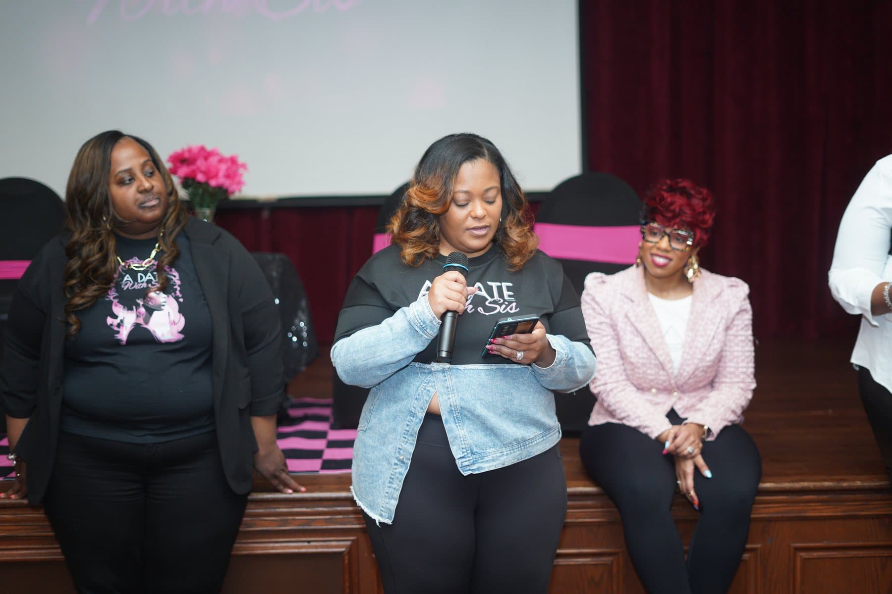 Women seated on stage during the program